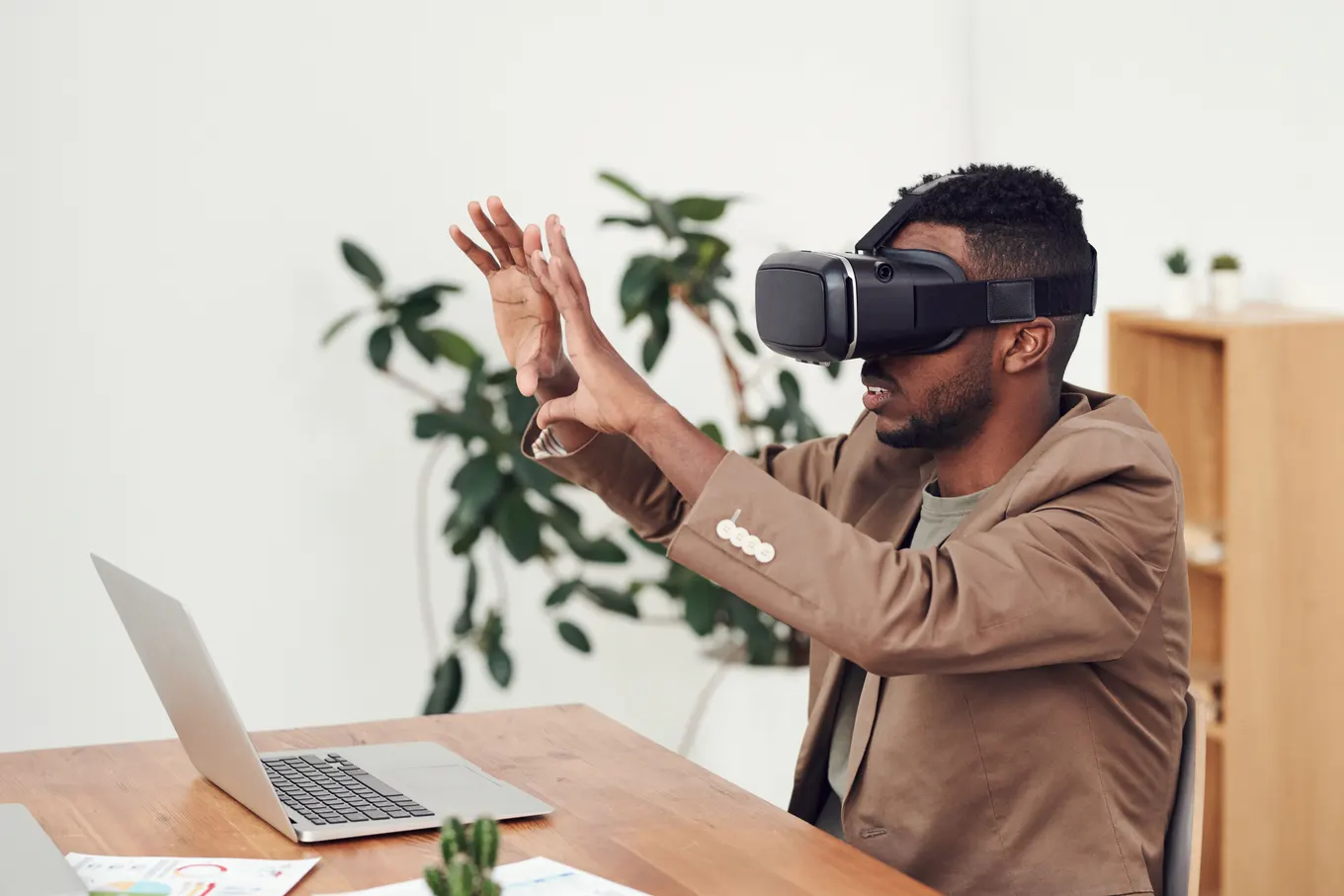 Office professional using a virtual reality headset beside a laptop
