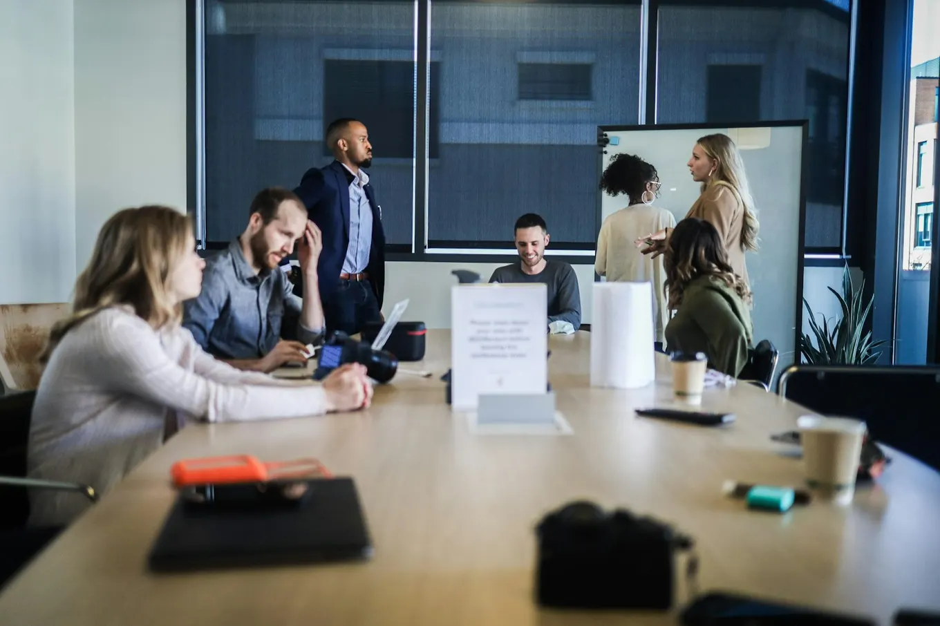 Team collaborating around a conference table with laptops